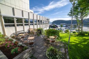 a patio with tables and chairs next to a building at Hotell Maritim Skjervoy in Skjervøy