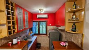 uma cozinha com paredes vermelhas e uma mesa em Vila Lena Banja Vrujci em Berkovac