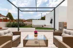 a patio with two couches and a glass table at Van Loui's II Place in Áyioi