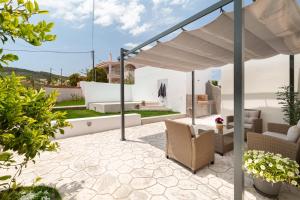 a patio with a table and chairs under a white umbrella at Van Loui's II Place in Áyioi