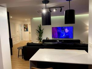 uma sala de estar com um sofá e uma televisão de ecrã plano em Apartment X Palm Village Mikocheni em Dar es Salaam