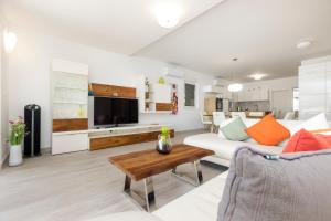 a living room with a white couch and a table at Apartments Tony in Mali Lošinj