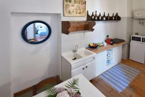 a kitchen with a sink and a table and a mirror at Il Drago al Roseto del Drago in San Bernardo