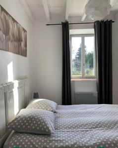Schlafzimmer mit einem Bett und einem Fenster in der Unterkunft Gite les PELATS in Cenne-Monestiès