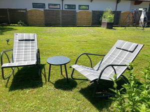 twee stoelen en een tafel in de tuin bij Haus zum Glück in Reifnitz