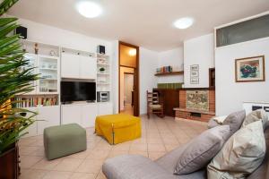 ein Wohnzimmer mit einem Sofa und einem TV in der Unterkunft [RELAX- 7 POSTI] A pochi passi dal mare in Porto San Giorgio