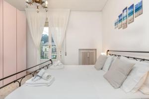 ein weißes Schlafzimmer mit einem großen weißen Bett und einem Fenster in der Unterkunft [RELAX- 7 POSTI] A pochi passi dal mare in Porto San Giorgio