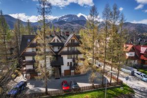 an apartment building with mountains in the background at VisitZakopane - Mango Apartment in Zakopane