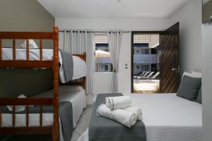 a bedroom with two bunk beds and a balcony at Hotel Pousada Porto da Lua in Guaratuba