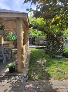 a wooden pavilion with a picnic table in a yard at Pokoje gościnne Cuma in Łeba