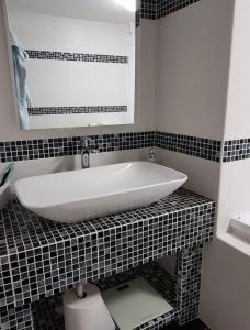 a bathroom with a white tub on a black tiled counter at Willa Różana in Rymanów-Zdrój