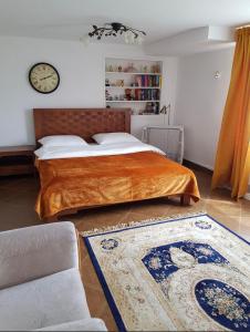 ein Schlafzimmer mit einem Bett und einer Uhr an der Wand in der Unterkunft Willa Różana in Rymanów-Zdrój