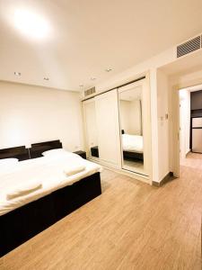 ein Schlafzimmer mit einem großen Bett und einem Spiegel in der Unterkunft central apartment for rent 26 in Umm Uthainah