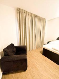 ein Wohnzimmer mit einem Stuhl und einem Bett in der Unterkunft central apartment for rent 26 in Umm Uthainah
