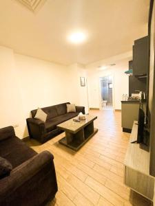 ein Wohnzimmer mit einem Sofa und einem Tisch in der Unterkunft central apartment for rent 26 in Umm Uthainah