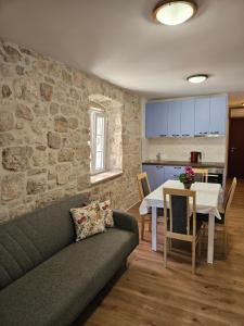 un soggiorno con un divano e un tavolo di APARTMAN ELI a Supetar (San Pietro di Brazza)