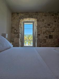 una camera da letto con un letto grande e una finestra di APARTMAN ELI a Supetar (San Pietro di Brazza)