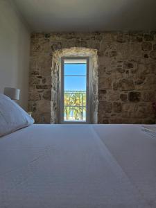 a bedroom with a large bed and a window at APARTMAN ELI in Supetar