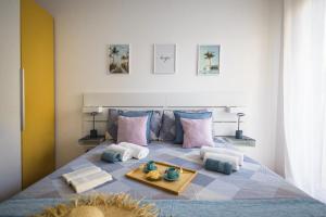 1 dormitorio con 1 cama grande con almohadas rosas y azules en ELEGANT HOUSE BY THE SEA RAPALLO - 50 meters from the beach ,near Portofino, en Rapallo 44 fotos más