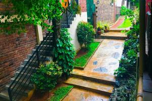 un jardín con un árbol y un edificio de ladrillo en Veraima Kandy en Kandy