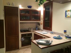 a kitchen with wooden cabinets and a stove top oven at Villa Giuliana in San Vito lo Capo +109 photos