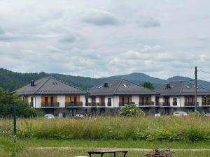 une rangée de maisons avec banc dans un champ dans l'établissement Sosnówka Lake Apartament, à Sosnówka