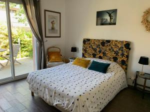a bedroom with a bed with a headboard and a patio at Maudon Coeur de Baie in Ponts
