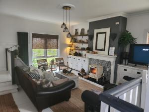 a living room with a couch and a fireplace at Faithlegg Hotel Lodge in Waterford