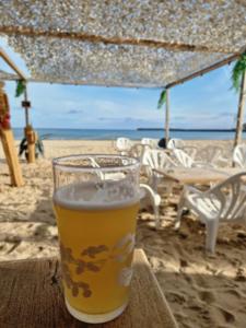 un bicchiere di birra seduto su un tavolo sulla spiaggia di Studio cœur des Sables, 100m de la plage a Les Sables-dʼOlonne