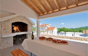 un patio con chimenea de piedra y una mesa con comida en Nice Home In Zmijavci With Private Swimming Pool, Can Be Inside Or Outside, en Zmijavci