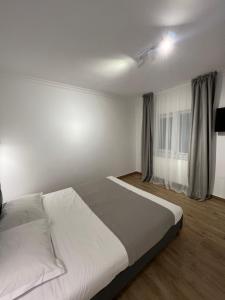 1 dormitorio con 1 cama blanca grande y ventana en Nord 22 en Constanza
