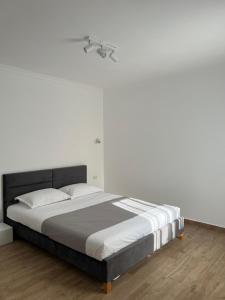 a bedroom with a large bed with white walls at Nord 22 in Constanţa