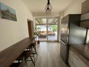 a kitchen with a table and a stainless steel refrigerator at Dom Marhuľa in Štúrovo