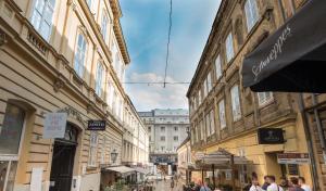 a group of people walking down a street with buildings at Apartment Palazzo, Zagreb town centre in Zagreb