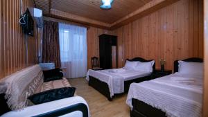Cette chambre comprend 2 lits et une télévision. dans l'établissement Дом отдыха ира, à Ureki