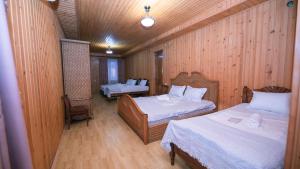 a room with two beds in a wooden wall at Дом отдыха ира in Ureki