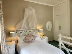 a bedroom with a white bed with a canopy at The Bardolino Artists Retreat in Nelspruit