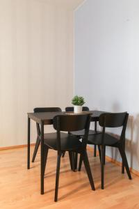een zwarte eettafel en stoelen met een potplant bij City Apartment Satamantupa in Kuopio