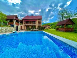a large swimming pool in front of a house at Купецький Двір in Mizhhirya