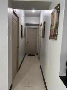 a hallway with white walls and a door and a tile floor at Spacious 3BR Manhattan Parkview Tower 2 in Manila