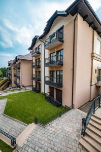 an apartment building with a lawn in front of it at Helena apartman in Ocka Gora