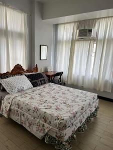 a bedroom with a bed and a table and curtains at Spacious 3BR Manhattan Parkview Tower 2 in Manila