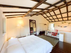 een slaapkamer met een wit bed en een bureau bij La Casa del Poeta Enna - Pergusa in Enna