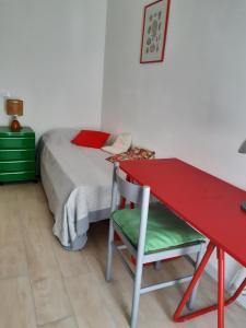 een slaapkamer met een rood bureau en een bed bij Casa Dino in Rosignano Solvay