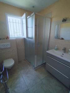bagno con doccia, lavandino e servizi igienici di Villa près des remparts a Régusse