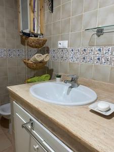 een badkamer met een witte wastafel en een toilet bij Appartement en résidence + grande terrasse sur le toit in Saidia 