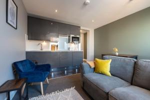 a living room with a couch and a table and a kitchen at Sea Shell - 1 Bedroom Flat in Brighton & Hove