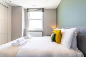 a bedroom with a large white bed with towels on it at Sea Shell - 1 Bedroom Flat in Brighton & Hove