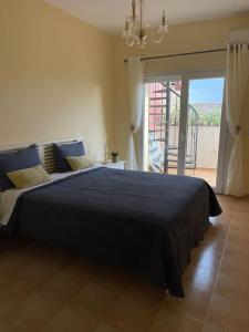 een slaapkamer met een groot bed en een blauwe deken bij Appartement en résidence + grande terrasse sur le toit in Saidia 