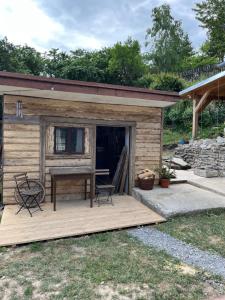 eine Hütte mit einem Tisch und Stühlen auf einer Terrasse in der Unterkunft Chalupa Vojtěchov 60 in Hvozd